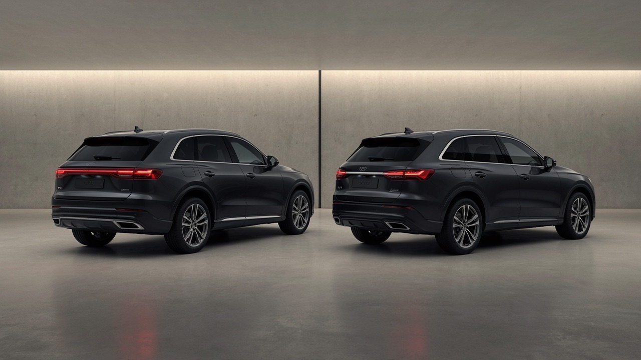 รถ SUV สีเทาเข้มสองคันต่างรุ่นจอดเทียบกันในโชว์รูม มองจากด้านท้าย